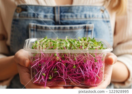 Ai generated Close up of female hands holding red plate with small microgreens plant 122928995