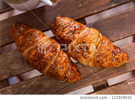 Several twisted croissants with stuffing lie against background of simple wooden table. Several twisted croissants with stuffing lie against background of simple wooden table. 122929032