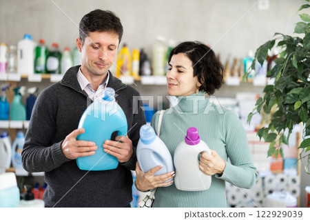 Married couple chooses detergent in household goods department of supermarket Married couple chooses detergent in household goods department of supermarket 122929039