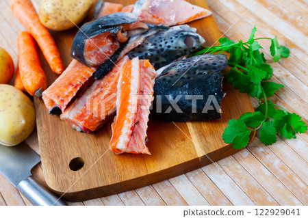 Chunks of raw salmon and fresh vegetables - ingredients for preparing delicious lunch Chunks of raw salmon and fresh vegetables - ingredients for preparing delicious lunch 122929041