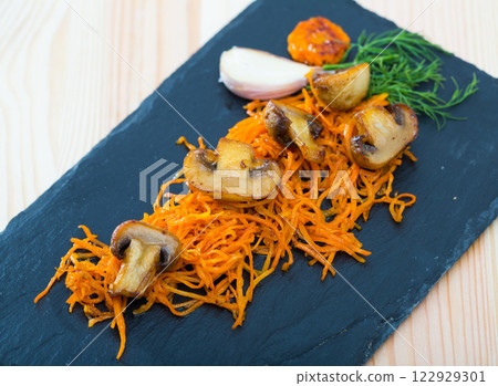 Roasted champignons with julienne carrots 122929301