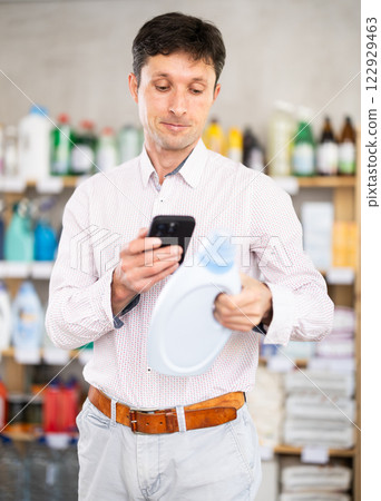 Man uses barcode to get information about liquid laundry conditioner in mobile application. 122929463