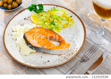 Salmon served with potatoes and salad 122929596