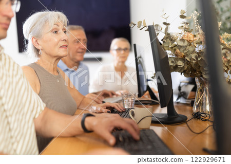Old woman learning computer programs in training room 122929671