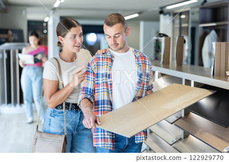 Couple man and woman choosing laminate flooring Couple man and woman choosing laminate flooring 122929770