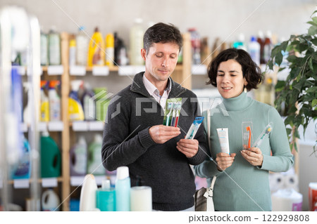Couple man and woman choosing toothbrush in store 122929808