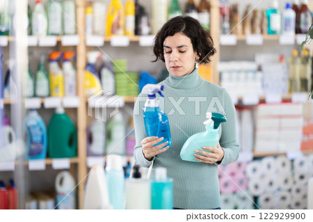 Middle-aged woman choosing cleaning spray at department store 122929900