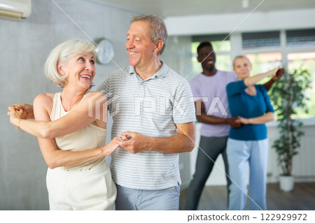 Mature male novice student of fitness studio practices paired Latin American rumba dance 122929972