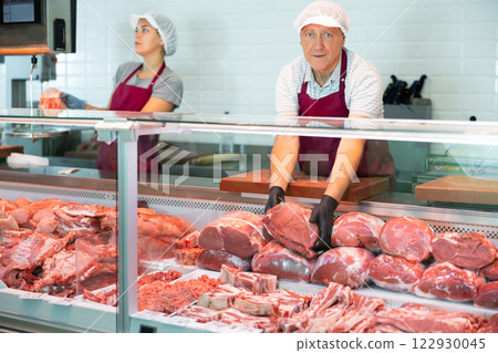 Male farmer of meat products in butcher shop offers to buy fresh beef tenderloin. Male farmer of meat products in butcher shop offers to buy fresh beef tenderloin. 122930045
