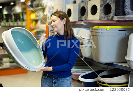 Confident woman choosing plastic litterbox for cats in pet shop Confident woman choosing plastic litterbox for cats in pet shop 122930085