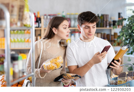 Couple man and woman scanning qr code for pasta Couple man and woman scanning qr code for pasta 122930203