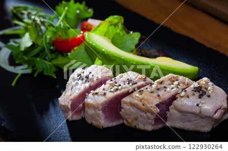 Slightly fried tuna with avocado and greens Slightly fried tuna with avocado and greens 122930264