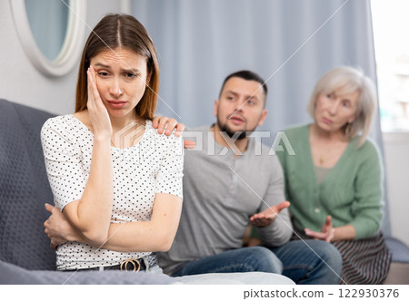 Depressed young woman during conflict with family at home 122930376