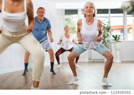 Portrait of active mature women enjoying modern energetic dancing in a group in studio Portrait of active mature women enjoying modern energetic dancing in a group in studio 122930502