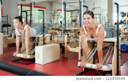 Young woman doing exercises on pilates machine Young woman doing exercises on pilates machine 122930594