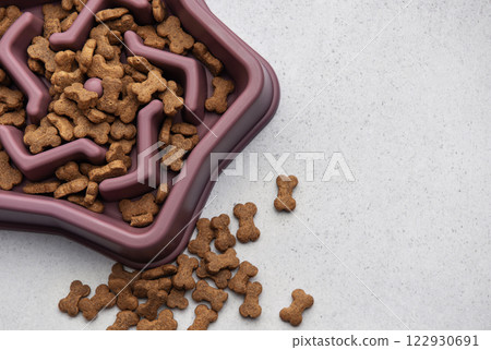 Dry dog food in bowl slowing eating process for overweight dogs Dry dog food in bowl slowing eating process for overweight dogs 122930691