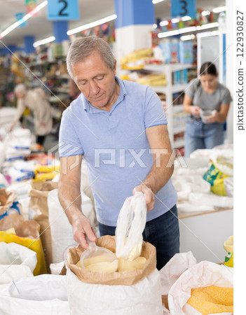 Aged man buying corn flour in grocery store 122930827