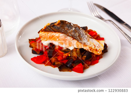 Salmon steak stewed vegetables served on table 122930883