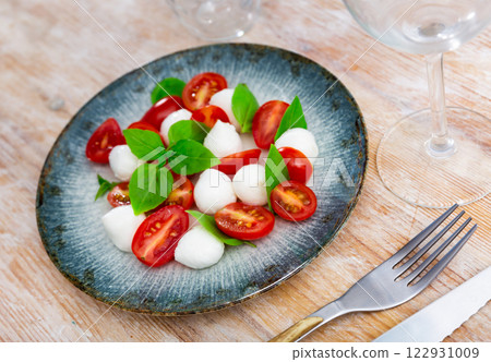 Caprese salad with mozzarella and tomatoes Caprese salad with mozzarella and tomatoes 122931009