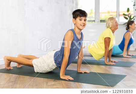 Family doing cobra asana exercise. 122931033