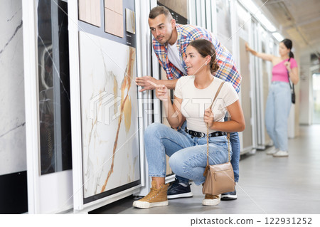Couple of man and woman choose tiles in store Couple of man and woman choose tiles in store 122931252