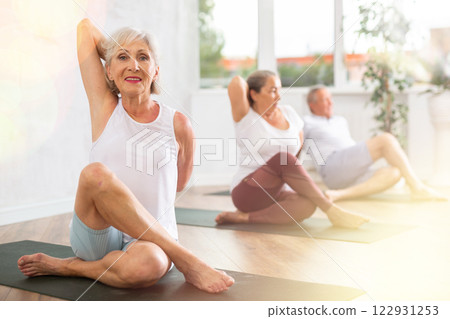 Senior lady performs cow head pose, Gomukhasana Senior lady performs cow head pose, Gomukhasana 122931253