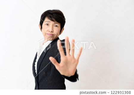 A middle-aged woman in a suit sticking out her hand to warn others A middle-aged woman in a suit sticking out her hand to warn others 122931308