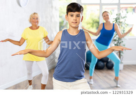 Happy preteen boy practicing dance positions during workout session 122931329