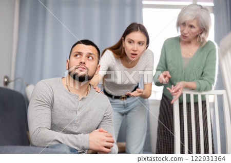 Man dont speaking after discord with mother and wife standing behind Man dont speaking after discord with mother and wife standing behind 122931364