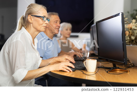 Old woman learning computer programs in training room 122931453