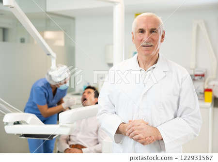 Senior man doctor is standing in dental office, clinic 122931567