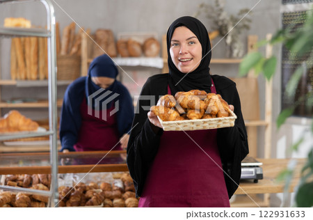 Hospitable saleswoman presenting traditional pastries in Muslim bakery 122931633