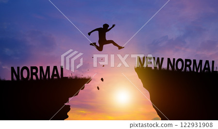 Silhouette man jumping over New Normal wording on cliffs with cloud sky and sunrise. New Normal and Freedom challenge Concept. 122931908