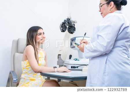 Optometrist with female patient taking notes in office. Female patient having consultation with optometrist in office 122932789