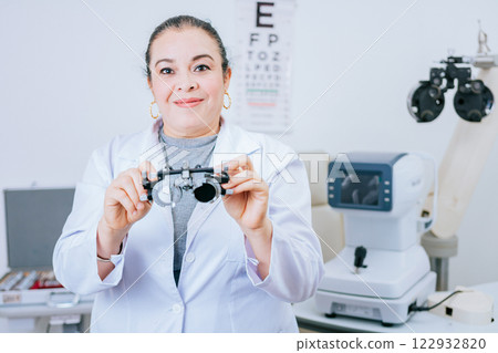 Portrait of optometrist holding messbrille lens in laboratory. Optometrist specialist holding optometric trial frame 122932820