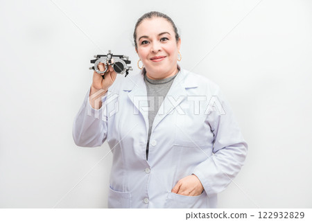 Portrait of female optometrist holding a messbrille lens isolated. Smiling ophthalmologist holding a messbrille isolated 122932829