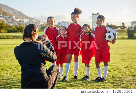 Soccer, photograph and sports coach with a girl team posing for a picture outdoor on a football field for fitness or training. Exercise, teamwork and picture with athlete kids or friends outside 122933101