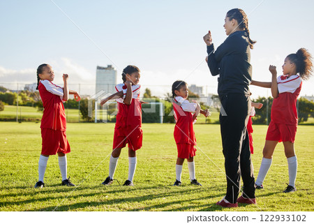 Fitness soccer, girl team and stretching with sport coach on sports field training, exercise or workout. Children, kids or coaching in diversity, teamwork and collaboration on warm up for game. 122933102