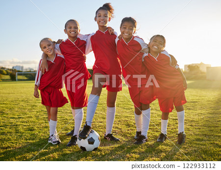 Soccer, team sports and portrait of children training for football game on a grass field together. Happy, smile and young group of girl athletes in partnership and teamwork for sport match at school 122933112