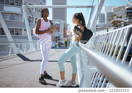 Fitness fashion, women friends and outdoor with water bottle and bag for outdoor workout motivation, collaboration or healthy lifestyle. Sports diversity people exercise training on urban city bridge 122933353