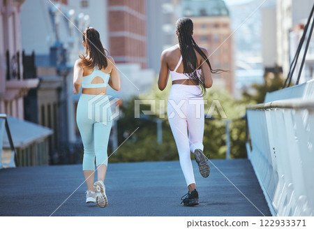 Women running in the city, training for fitness and exercies to stay healthy for good cardiovascular health. Woman friends run together, do cardio exercise in the sunshine and workout to lose weight Women running in the city, training for fitness and exercies to stay healthy for good cardiovascular health. Woman friends run together, do cardio exercise in the sunshine and workout to lose weight 122933371