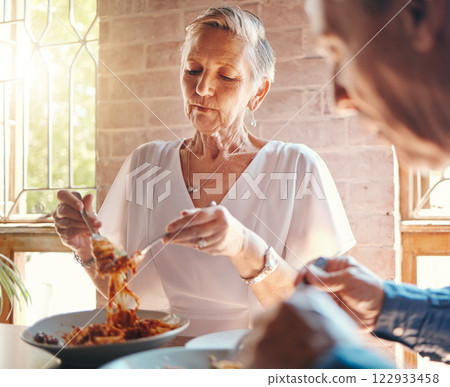 Old couple eating pasta at restaurant together on a date celebrating anniversary. Food, romantic dinner and senior man and woman enjoying spaghetti in Italian diner for marriage and love celebration 122933458