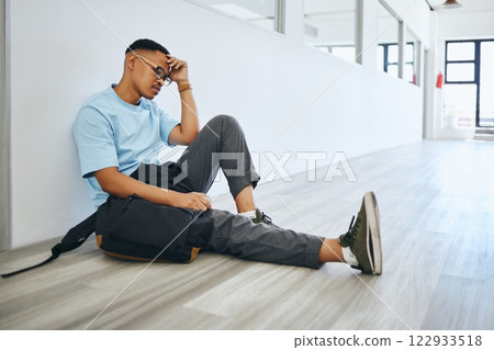Depression, mental health and student thinking on a floor, stress and social anxiety at university. Fear, debt and bully risk by black man hiding in an empty lobby, looking hopeless and overwhelmed 122933518