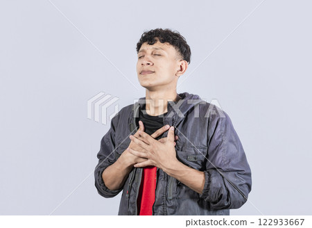 Attractive positive looking friendly young man with charming sincere smile feeling thankful, A man Attractive Peaceful Kind Grateful Guy, friendly man with closed eyes touching his chest Attractive positive looking friendly young man with charming sincere smile feeling thankful, A man Attractive Peaceful Kind Grateful Guy, friendly man with closed eyes touching his chest 122933667