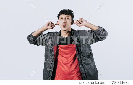 Person sticking out tongue making fun, Man covering ears and sticking out tongue, guy covering his ears making fun, man with hands on ears and making fun 122933683