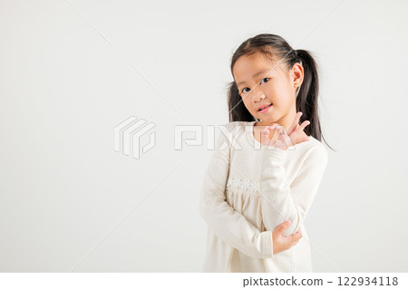 Exuberant young kid girl showcases the OK sign with an optimistic smile, conveying agreement and positivity isolated on a white background, ideal for your text customization. kindergarten child smile 122934118