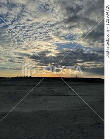 Vast barren landscape under a dramatic sunset sky 122934726