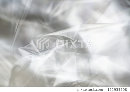 Crumpled clear plastic background, abstract glossy broken surface texture with creases 122935308