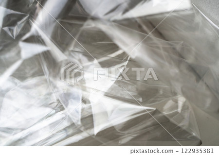 Crumpled clear plastic background, abstract glossy broken surface texture with creases Crumpled clear plastic background, abstract glossy broken surface texture with creases 122935381