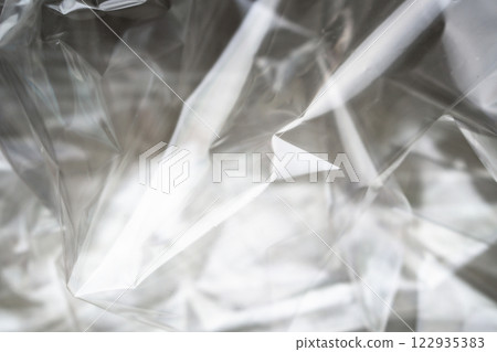 Crumpled clear plastic background, abstract glossy broken surface texture with creases Crumpled clear plastic background, abstract glossy broken surface texture with creases 122935383